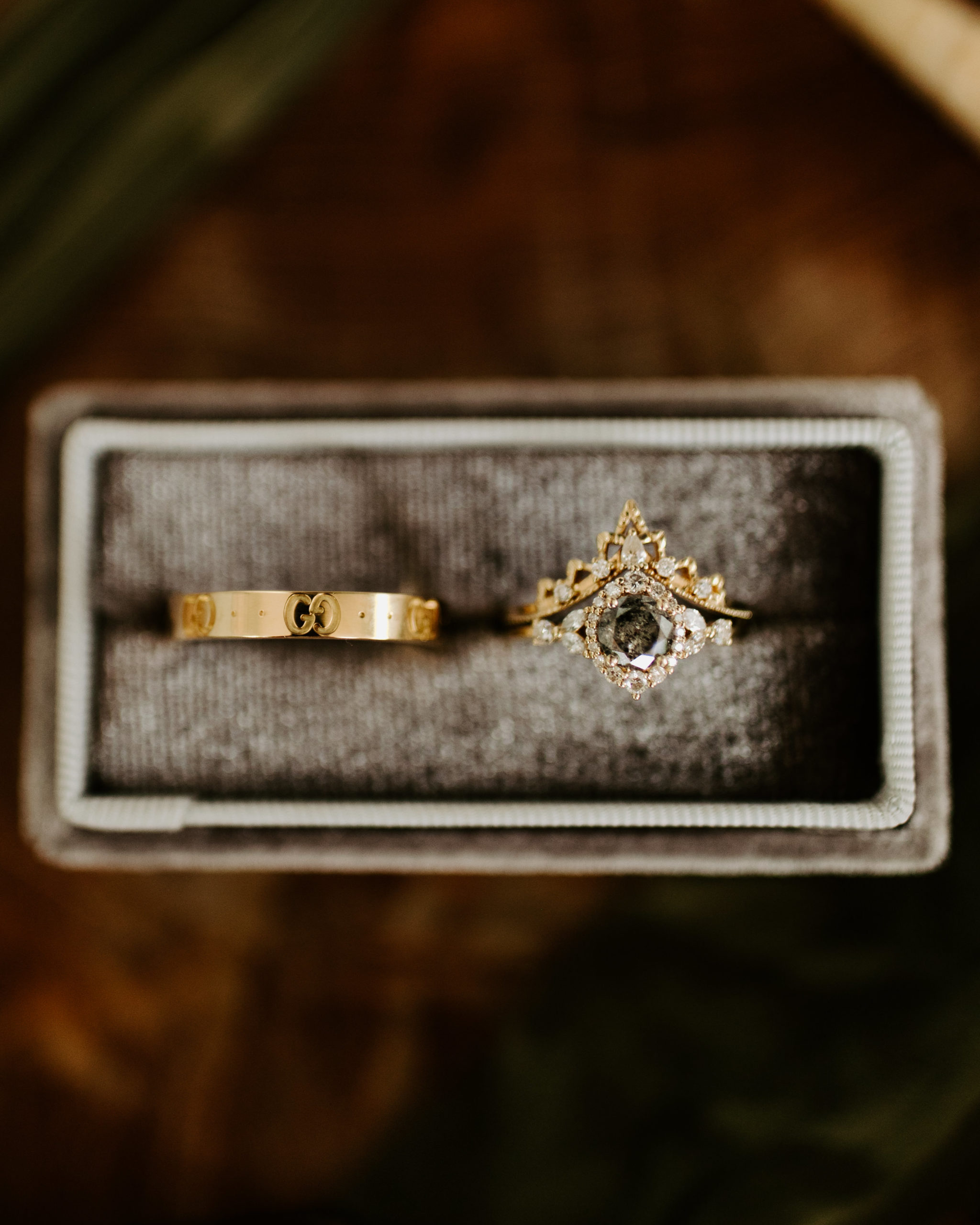Wedding day detail shot of wedding couple's rings. Grey diamon and gold mens wedding band set. 
