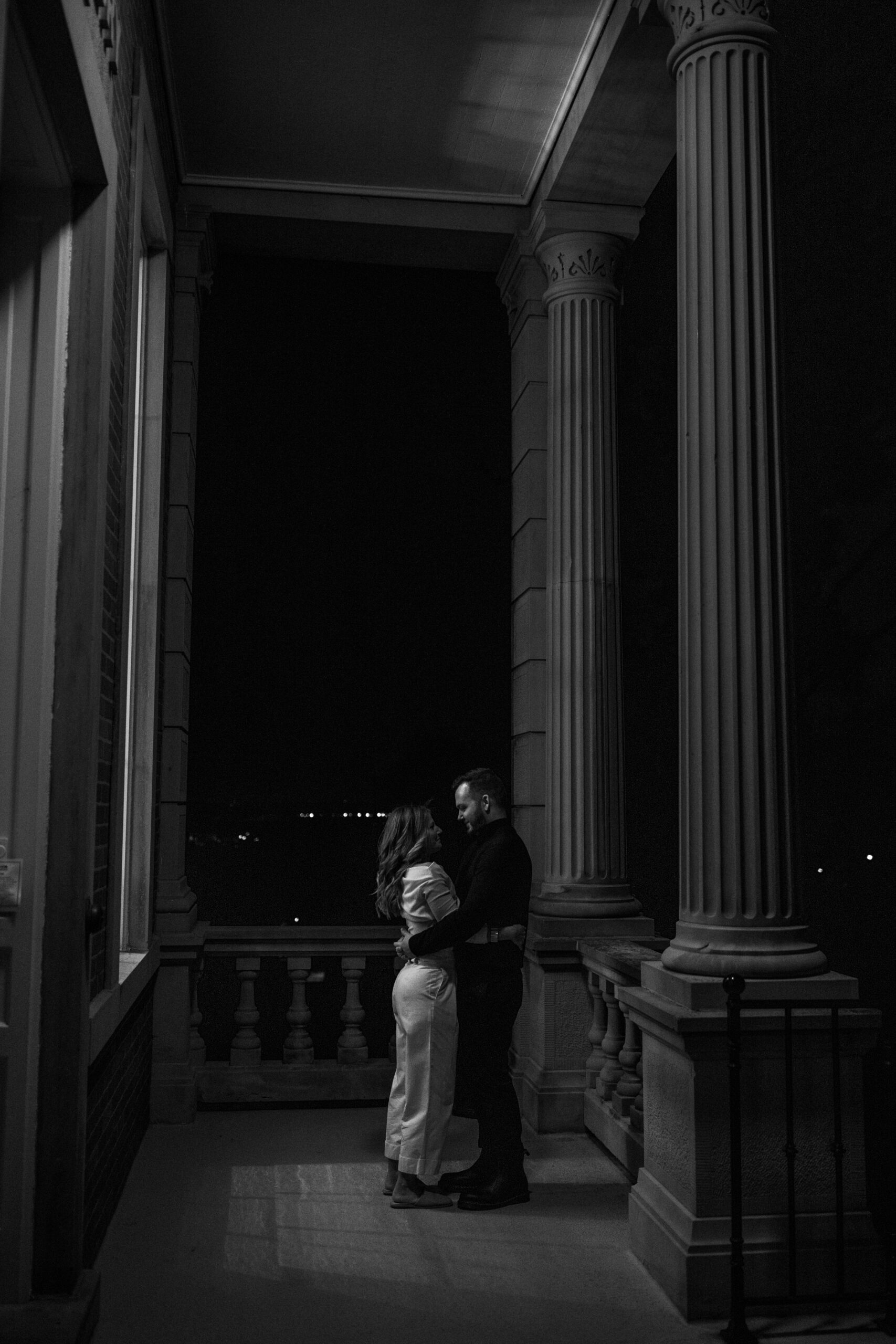 A black and white photo of a couple at their observatory engagement session. 