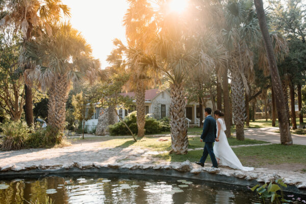 A wedding couple walking by the ponds at Mayfield Cottage and Gardens. 