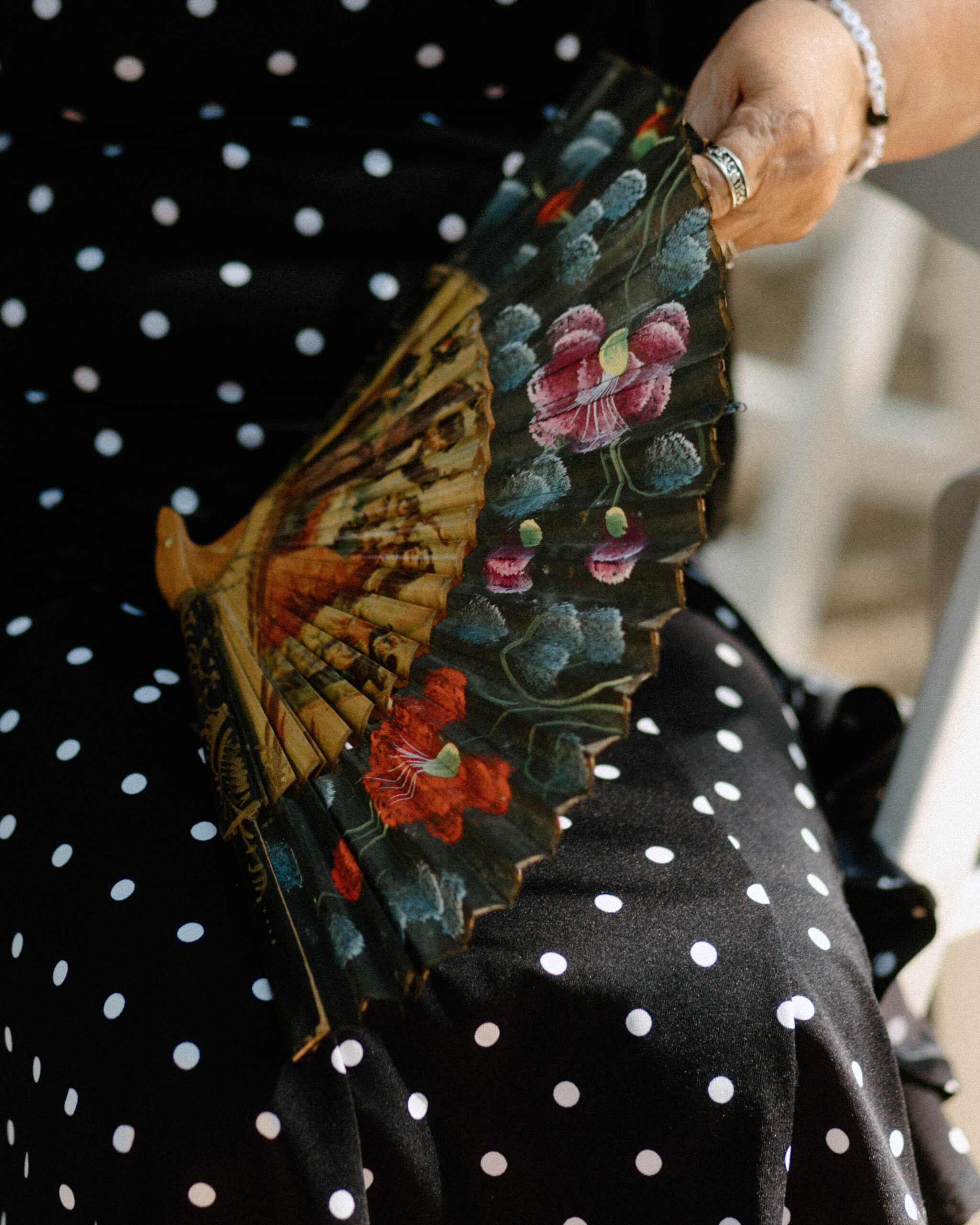 Photograph of woman fanning herself at a summer wedding.