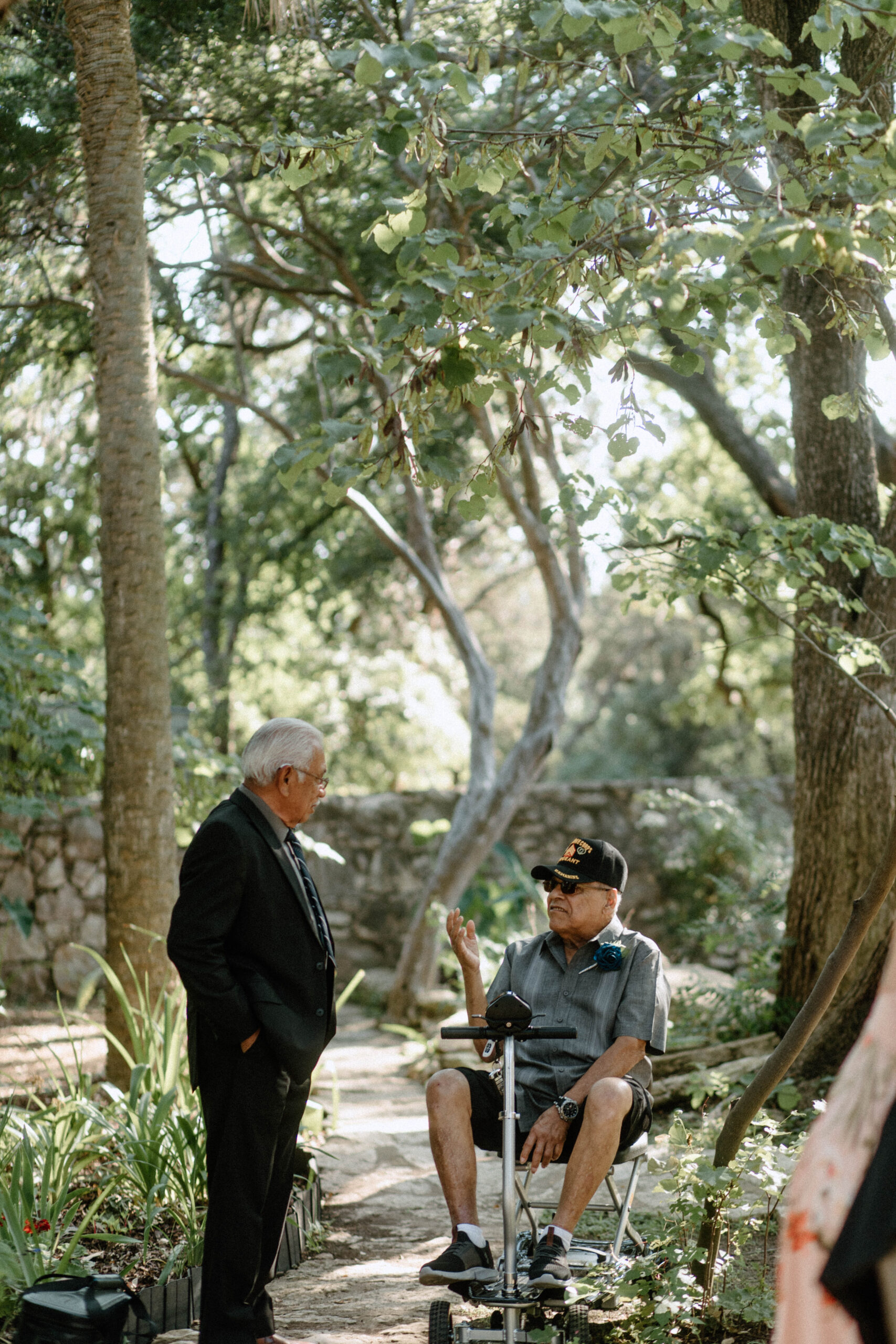 Documentary wedding photo of guests interacting at a summer garden wedding.