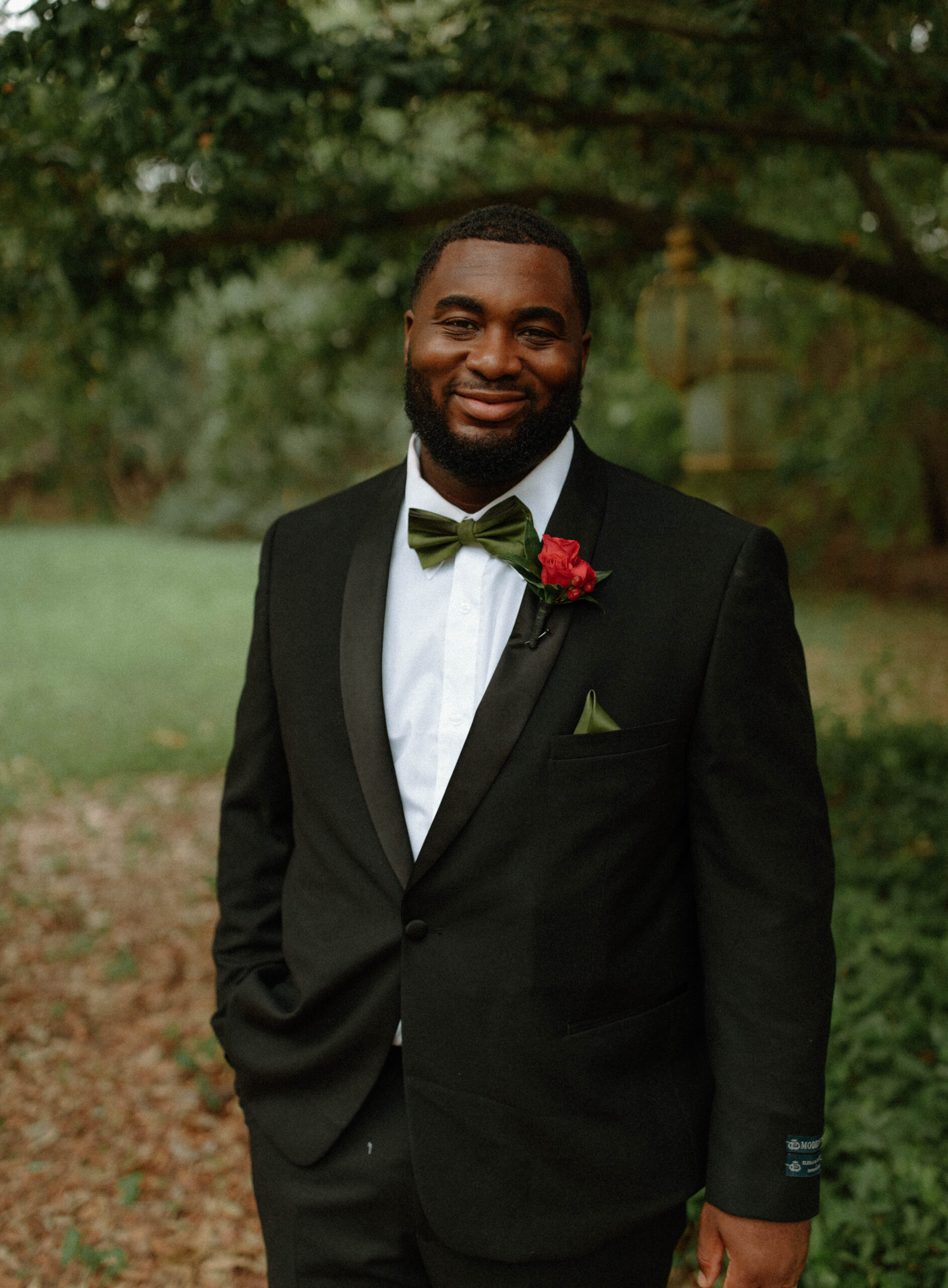 Groom's wedding portraits outside of Sekrit Theater. Groom wearing a green bowtie and black suit. 