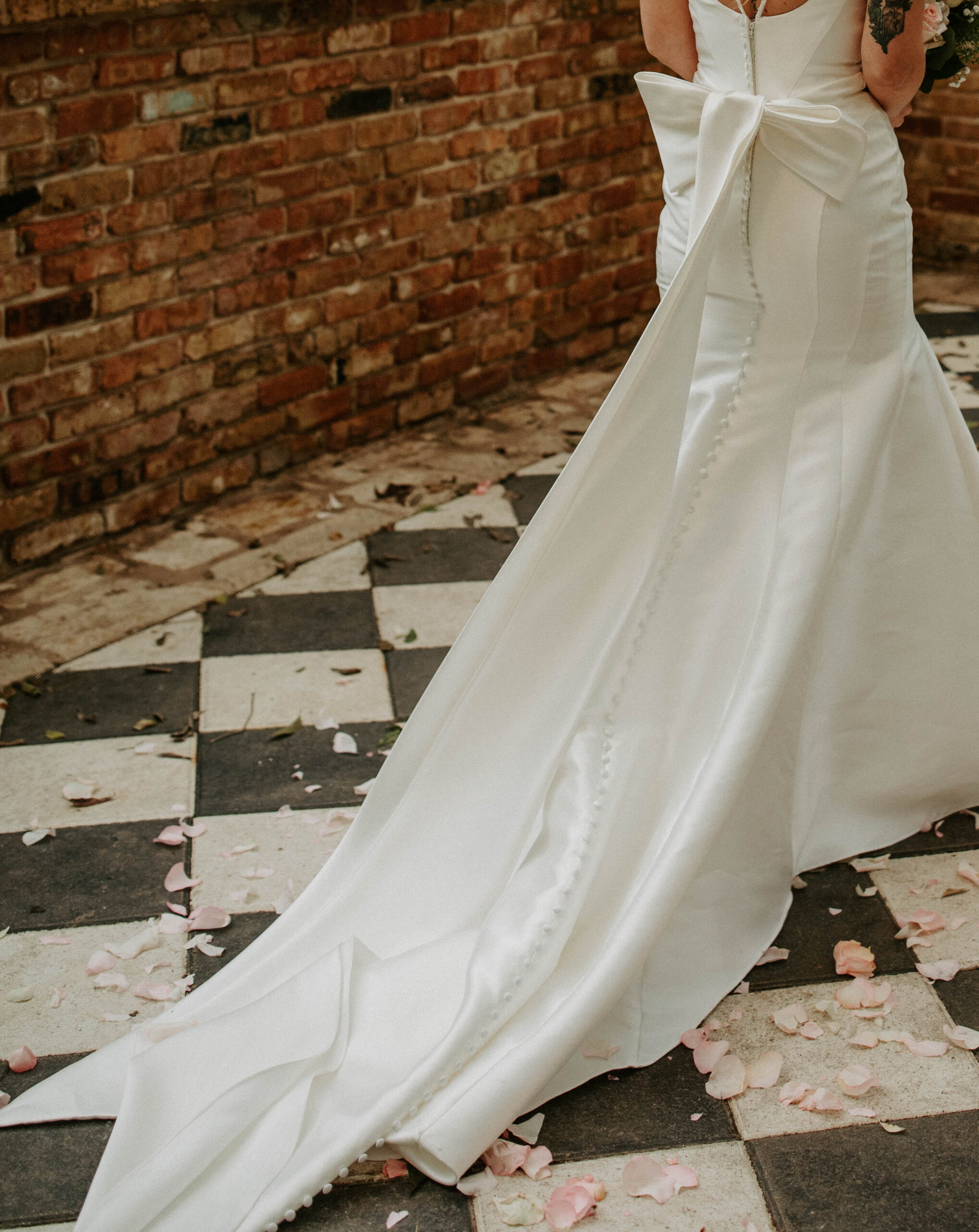 Bride in a white wedding dress with a large bow on the back, posing elegantly at Sekrit Theater in Austin. A beautiful setting for elopements and intimate weddings.