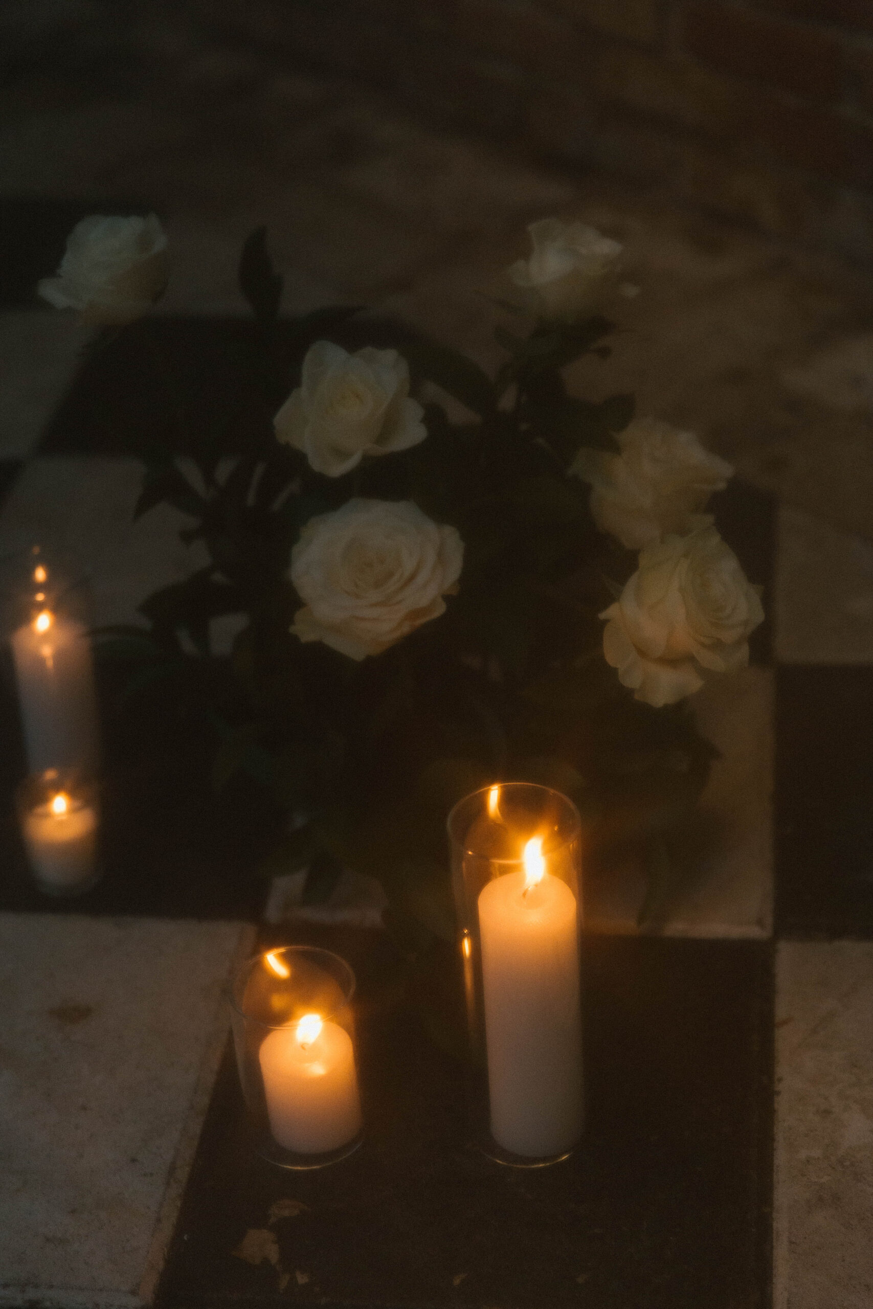 film photo of a white rose floral arrangement with pillar candles at the Sekrit Theater.