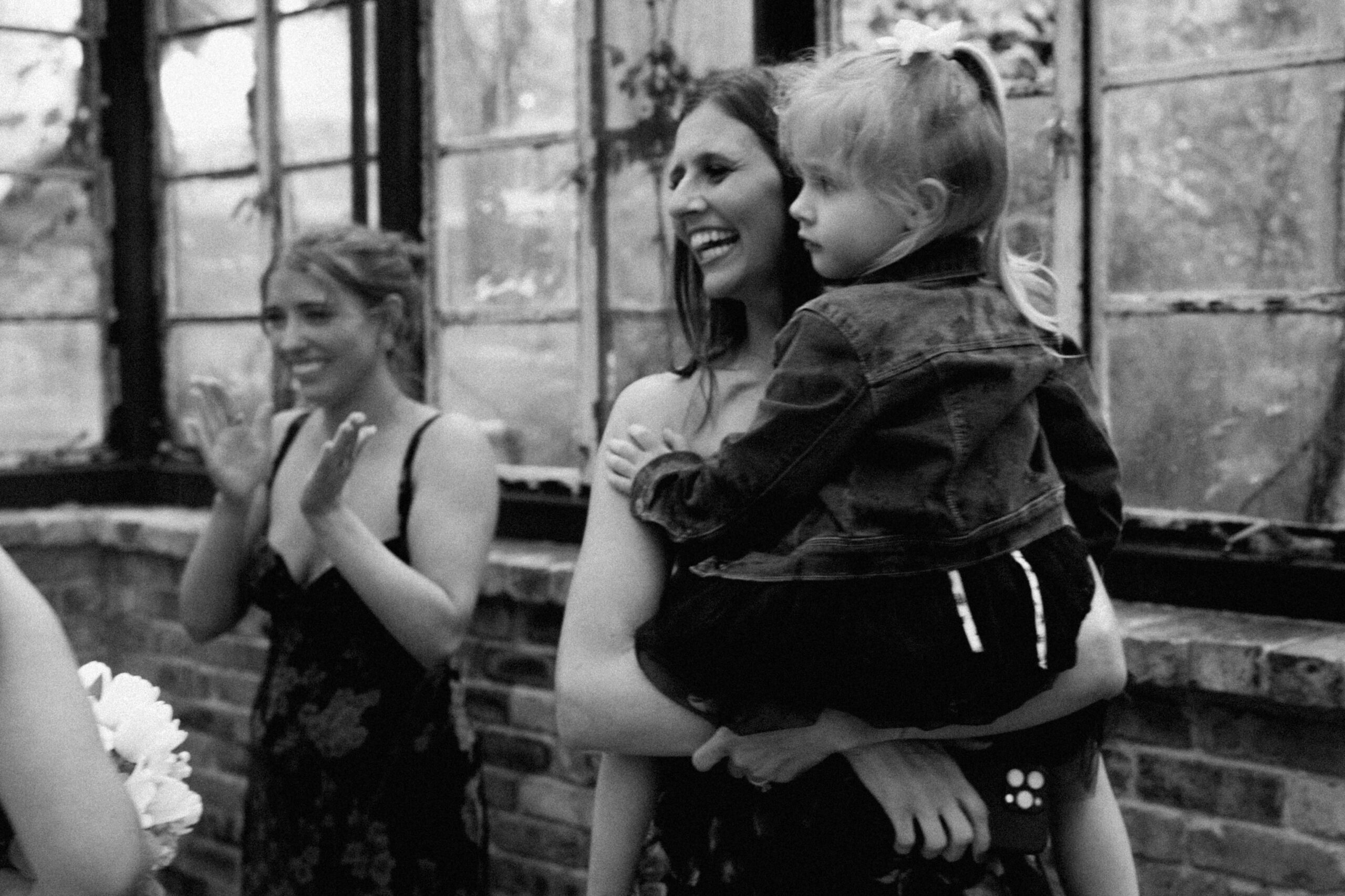 Candid of sisters smiling at their sister on her wedding day.