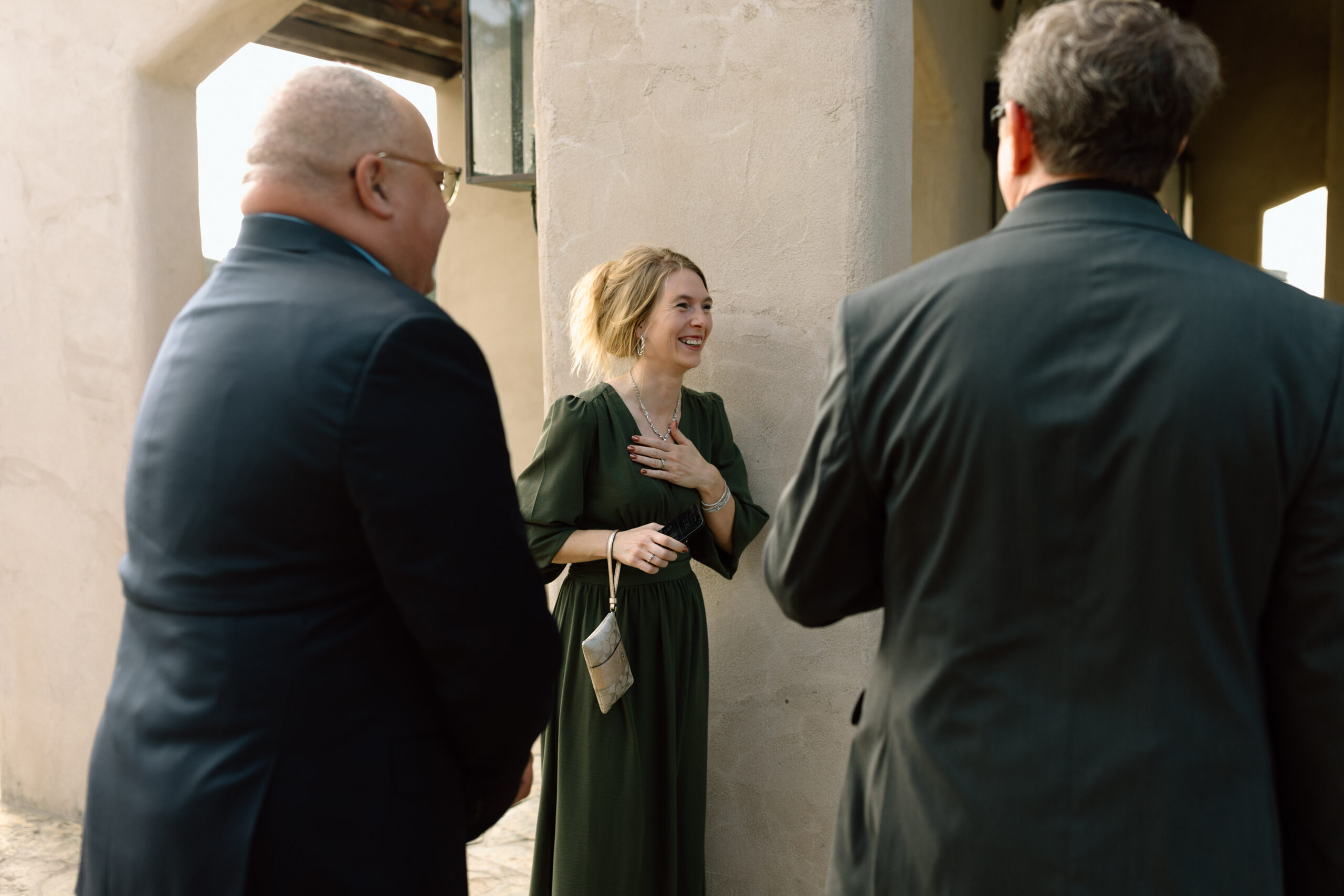 candid photograph of guests outside of a chapel laughing together.