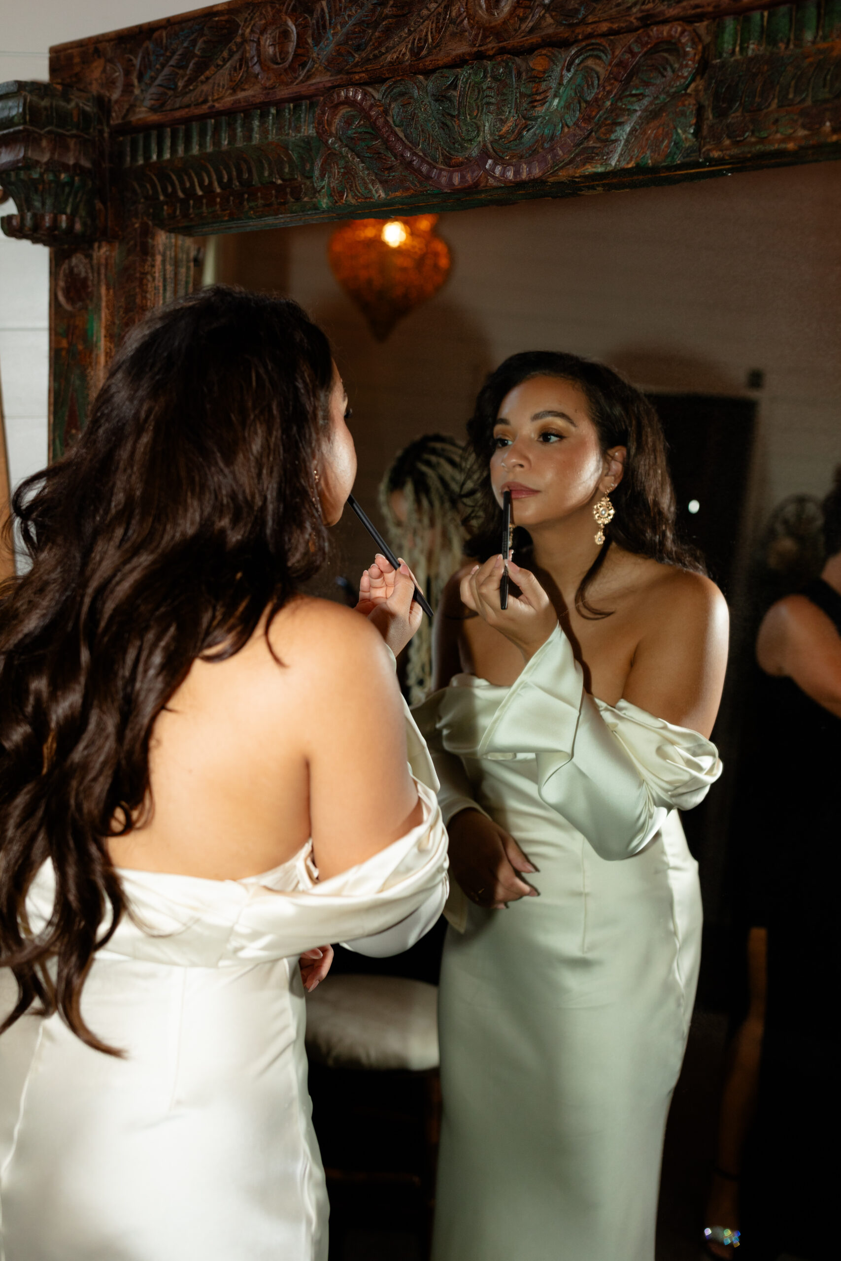 Bridal portrait of woman applying her lipstick