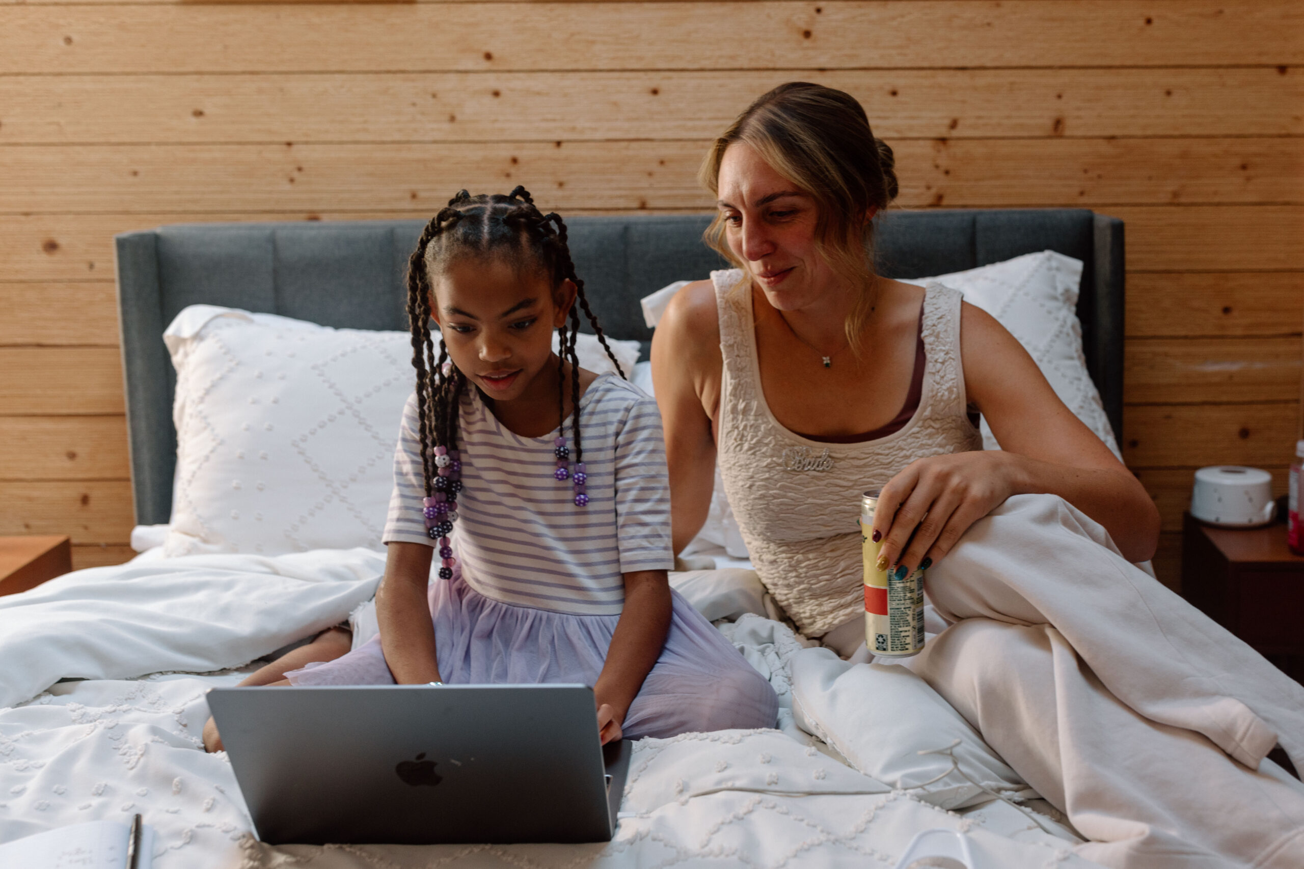 A woman on her wedding day sitting next to a child laughing.